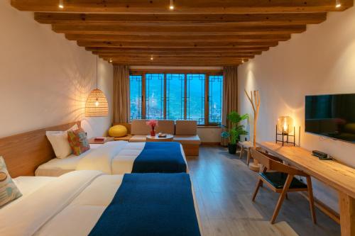 a hotel room with a large bed and a tv at Xijiang Sanchunli Zhong Panorama Meisu in Xijiang
