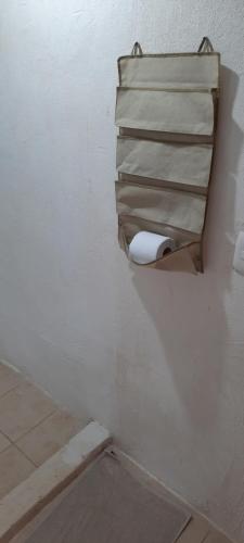 a bathroom with a toilet paper dispenser on the wall at La Casa de Leo - Hostal, Restaurante y Artesania local in San Juan de Oriente