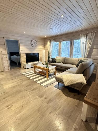 a large living room with a couch and a tv at Villa Polar Ylläs, Äkäslompolo in Äkäslompolo