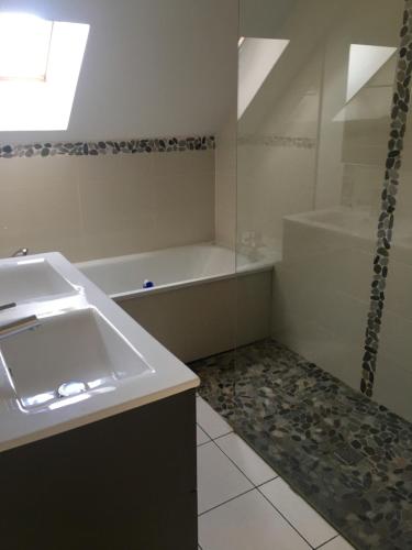 une salle de bain avec un lavabo et une baignoire dans l'établissement a 8kms du circuit des 24 h du mans, à Moncé-en-Belin