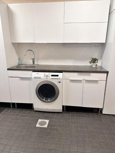 a white kitchen with a washing machine and a sink at Villa Polar Ylläs, Äkäslompolo in Äkäslompolo