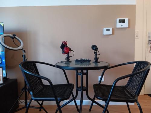 a table with two chairs and a table with microphones at Destiny Appart' Paris -Beauvais-Orly- Podcasts- Stade de France in Stains