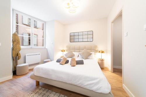 une chambre blanche avec un grand lit et deux fenêtres dans l'établissement La Tigresse Colmar Centre, à Colmar