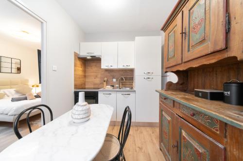 une cuisine avec une table et des chaises dans une pièce dans l'établissement La Tigresse Colmar Centre, à Colmar