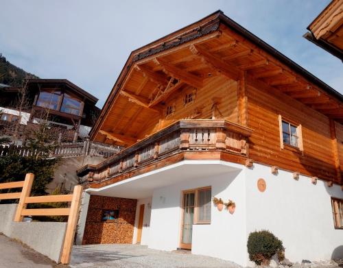 a wooden house with a balcony on top of it at Ferienhaus Stubaiblick in Neustift im Stubaital