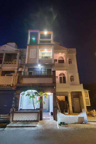a tall white building with a balcony at night at 邱比特民宿-恆春郵局正對面 in Hengchun