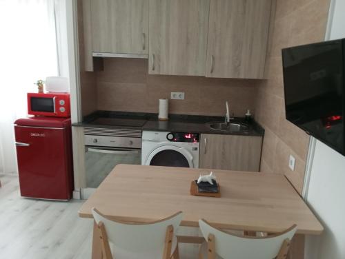 a kitchen with a table and a red refrigerator at EL RINCON DE CRISTINA in Perlora