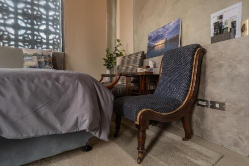 a bedroom with a chair next to a bed at 安樓文旅 Enzo House in Keelung
