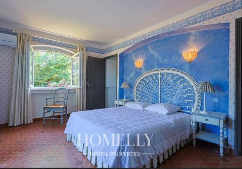 - une chambre bleue avec un grand lit et une fenêtre dans l'établissement Magnifique villa vue mer Ste Maxime - Villa Gabriella, à Sainte-Maxime