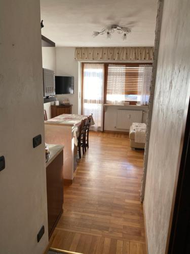 a kitchen and living room with a table and a dining room at Grazioso monolocale a Sestriere in Sestriere