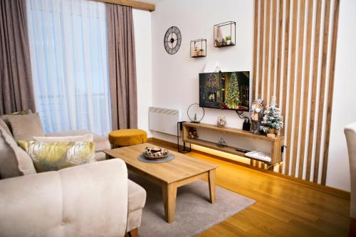 a living room with a couch and a coffee table at Apartman K&N - Jahorinska Vila in Jahorina