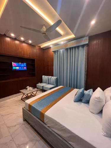 a bedroom with a large bed and a tv at Gulberg Inn Hotel Lahore in Lahore