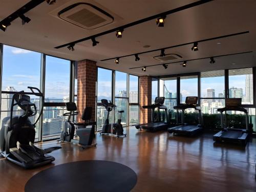 a gym with a lot of exercise equipment in a room with windows at Ceylonz Suites By ANA MALAYSIA in Kuala Lumpur