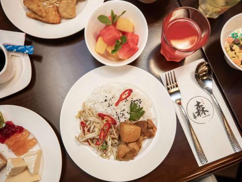 a table with plates of food on it at ibis budget Singapore Imperial in Singapore