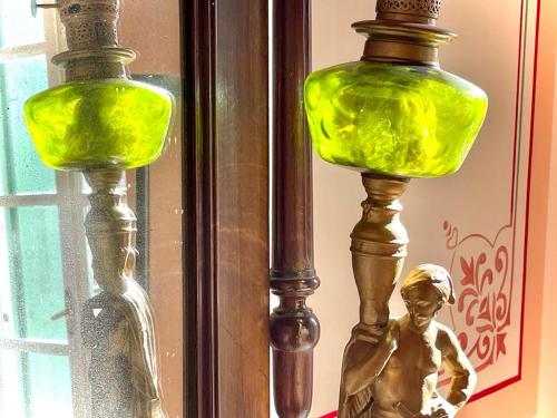 a green lamp with a statue next to a window at Gerofotis Traditional Guesthouse est 1892 - Close to Aigio, Akoli, Selianitika in Lákka