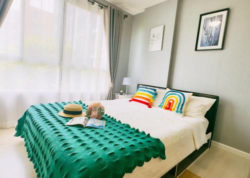 a bedroom with a bed with a green blanket on it at 乌托邦精品民宿1 in Chiang Mai
