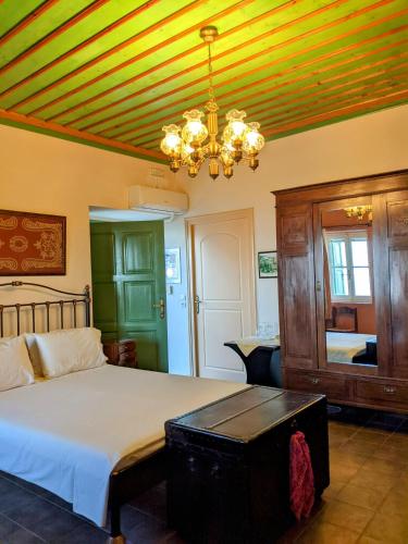 a bedroom with a bed and a chandelier at Gerofotis Traditional Guesthouse est 1892 - Close to Aigio, Akoli, Selianitika in Lákka