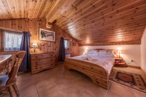 a bedroom with a bed in a wooden cabin at Chalet les Jardins Sauvages - Duplex Meribel in Les Allues