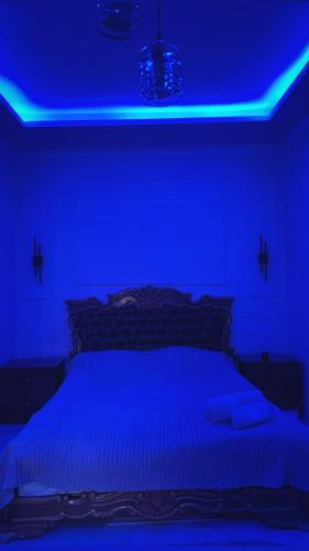 a blue bedroom with a bed with a blue lighting at Shirakatsi Guest House in Gyumri