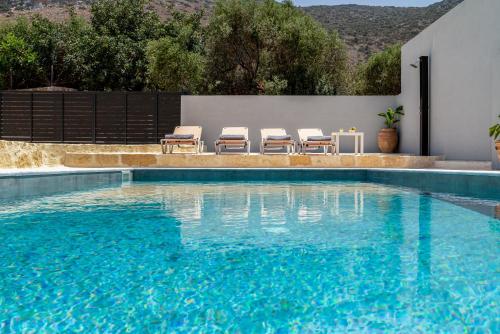 a swimming pool with four chairs at Villa Chrisa Seaview in Piskopiano - Private Pool in Piskopianon