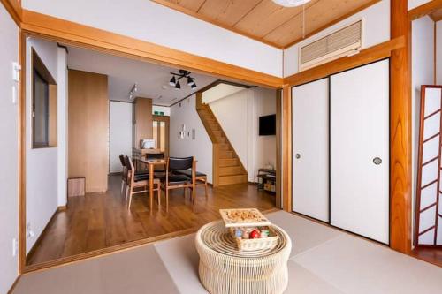 a living room with a table and a dining room at Nakamichi House 中道戸建 in Osaka