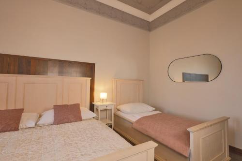 a bedroom with two beds and a mirror on the wall at Janackovo - Riverside Residence in Prague