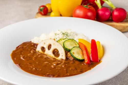 a plate of food with meat and vegetables and sauce at Hotel Ra Kuun in Hakone