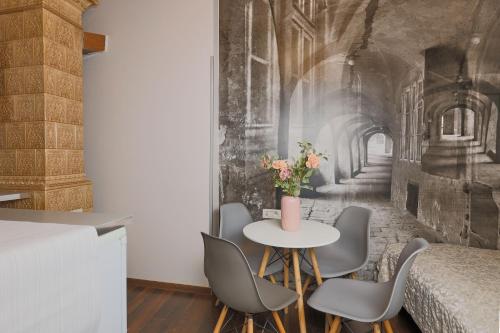 a dining room with a table with chairs and a wall mural at Janackovo - Riverside Residence in Prague