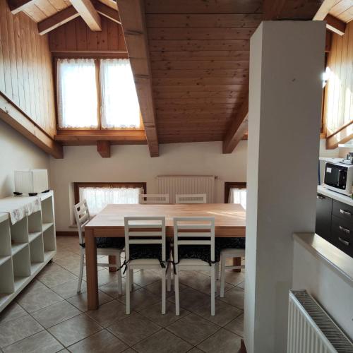 a kitchen and dining room with a table and chairs at Casa Daolasa Val di Sole Trentino in Commezzadura