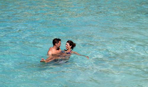 a man and a woman swimming in the water at Carimar Beach Club in Meads Bay