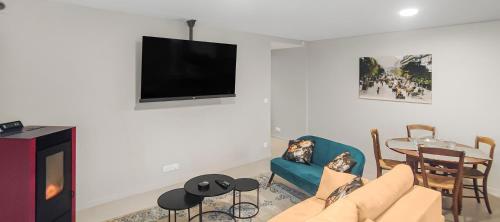 a living room with a tv and a couch and a table at ENTRE GUILLEMETS, Terrasse privée, 2 chambres, Parking privé, proche de Paris in Brétigny-sur-Orge
