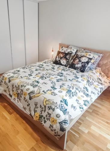 a bedroom with a bed with a floral bedspread at ENTRE GUILLEMETS, Terrasse privée, 2 chambres, Parking privé, proche de Paris in Brétigny-sur-Orge