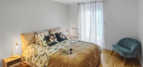 a bedroom with a bed and a blue chair at ENTRE GUILLEMETS, Terrasse privée, 2 chambres, Parking privé, proche de Paris in Brétigny-sur-Orge