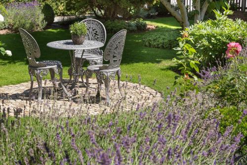 a table and chairs in a garden with purple flowers at Haus Sibylle in Bad Tölz