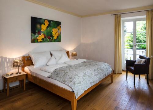 a bedroom with a bed and a chair and a window at Haus Sibylle in Bad Tölz