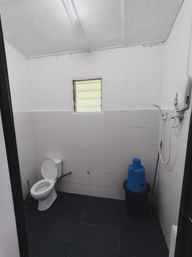 a bathroom with a toilet and a window at Rizkie homestay in Tanah Rata