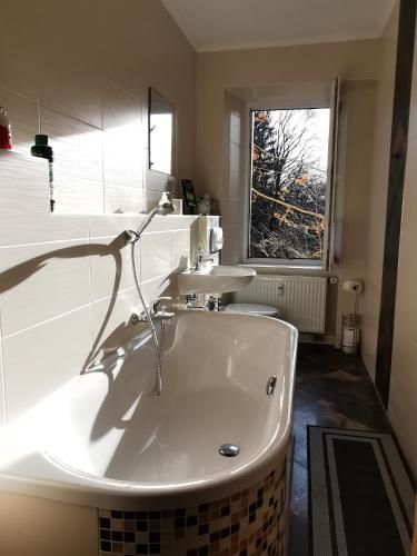 a large white tub in a bathroom with a window at Altstadt-Domizil in Annaberg-Buchholz