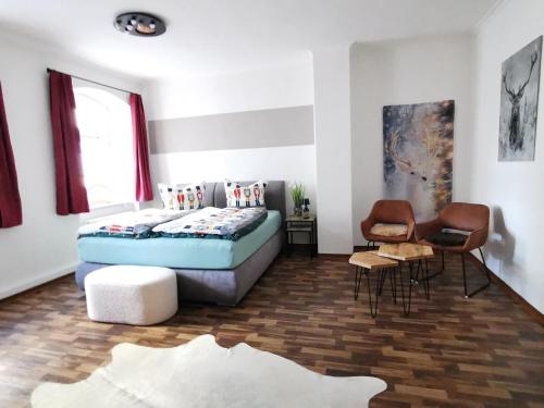 ein Schlafzimmer mit einem Bett, einem Tisch und Stühlen in der Unterkunft Altstadt-Domizil in Annaberg-Buchholz