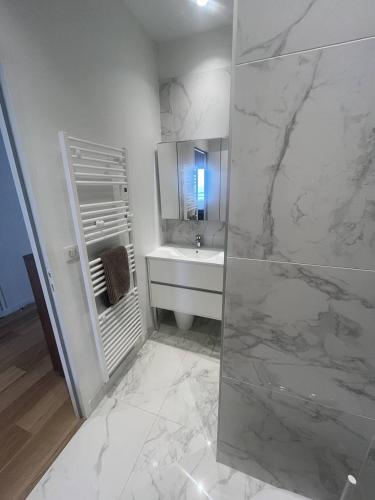 une salle de bain blanche avec un lavabo et une douche dans l'établissement Saint Jean de Luz, APPT 2 pièces équipé pour 4 pers, terrasse, vue océan, à Sainte-Barbe
