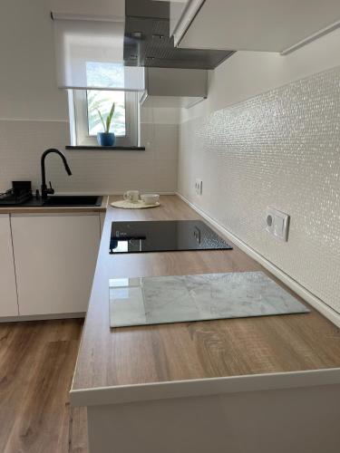 a kitchen with a sink and a counter top at Apartamento Tronqueiras in Praia da Vitória