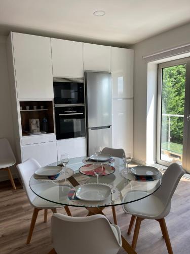 a dining room with a glass table and chairs at Apartamento Tronqueiras in Praia da Vitória
