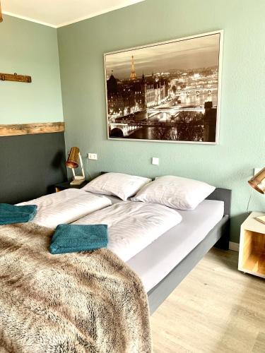 a bedroom with a large bed with a picture on the wall at Kappeberg Lodge in Winterberg