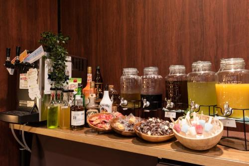 a bar with bottles of alcohol and bowls of food at Hotel Ra Kuun in Hakone