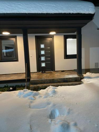 a house with a pile of snow in front of it at Vila Halima in Rožaje