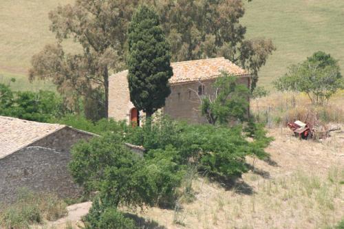 an old house in a field with a tree at Agriturismo Monaco Di Mezzo in Resuttano