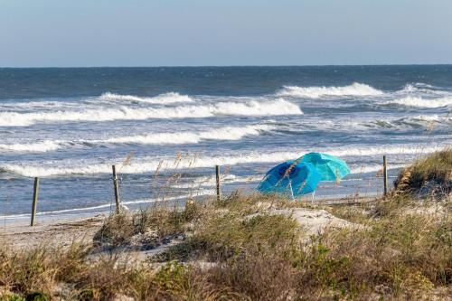 a blue umbrella on the beach near the ocean at Ebb Tide 703 in New Smyrna Beach