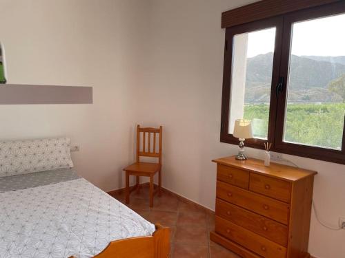 a bedroom with a bed and a dresser and a window at House Lago Azul in Cuevas del Almanzora