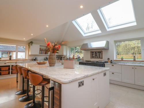 a kitchen with a large island in a kitchen with skylights at Blossom Hill in Witney