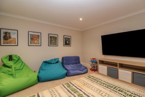 a living room with two chairs and a flat screen tv at Blossom Hill in Witney