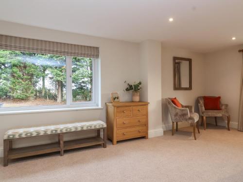 a room with a window and a bench and a dresser at Blossom Hill in Witney